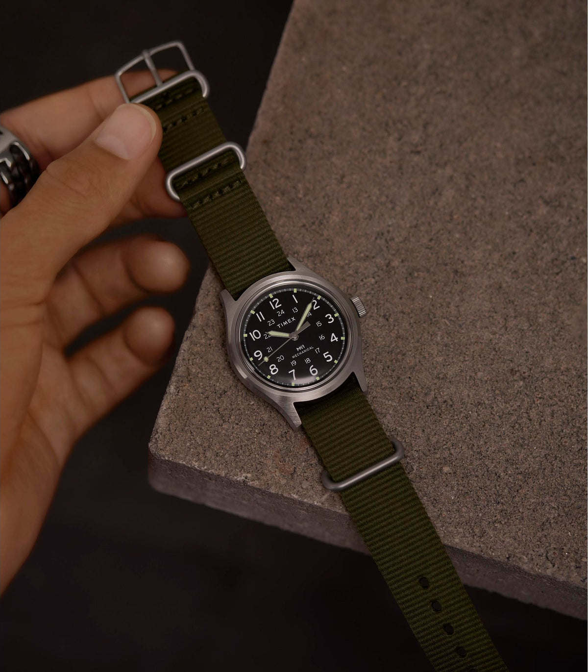 Timex de campo con correa verde sobre piedra